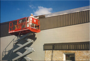 Roberge-Painting-Employees_Spraying building from lift_f
